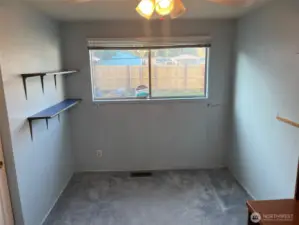 5th Bedroom at North end of House. Has blue carpet, and looks out to back yard.