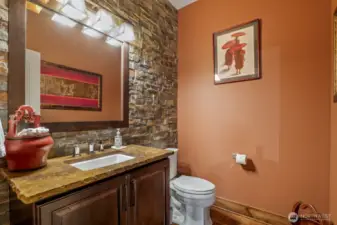 The 1/2 bath with stone wall off the entertainment area.