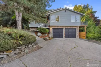 Welcome to 4312 Kiowa Drive! This inviting home features a charming brick facade, double garage with modern doors, and an extended driveway with additional parking space. Mature landscaping and stonework complement the private setting.