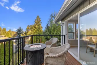A spacious deck overlooks lush greenery and offers an ideal spot for outdoor dining, barbecues, or morning coffee in a tranquil setting.