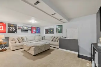 A versatile open space on the lower level provides options for a home office, workout room, playroom, or second living area with stylish lighting and neutral finishes ready to fit your lifestyle.