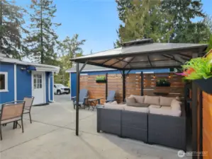 Inviting gazebo with string lights, comfy sectional sofa, and decorative planters—your go-to spot for outdoor lounging and stargazing.