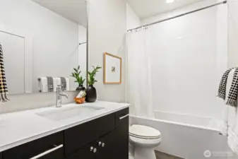 Photos of model home 9752 with similar finishes & floor plan. This full bath offers stylish finishes and sleek functionality—perfectly placed near the separated guest quarters.