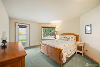 Lower-level bedroom with direct walkout access to the lawn and riverfront area, ideal for guests or multi-generational living.