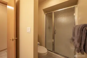Secondary bathroom with a spacious walk-in shower and sliding glass door for easy access.