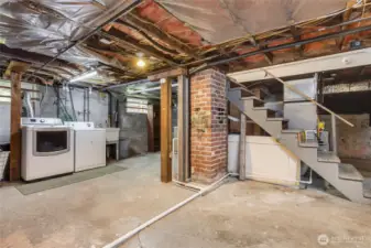 unfinished basement with included washer and dryer, sink and lots of storage.