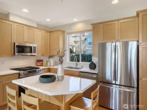 The remodeled kitchen offers new appliances including a gas range, new quartz counters, and a walk-in pantry next to it.