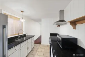 Kitchen also offers an undermount single-basin sink and tile flooring.