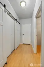 Hallway leading to the garage offers laundry space on the left and the entrance to a finished room on the right.