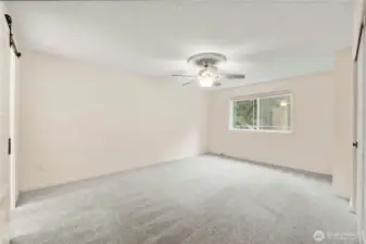 Spacious primary bedroom with ceiling fan.