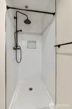 Primary bathroom features a tiled shower with a rain showerhead.