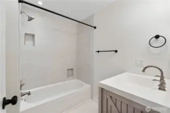 Full guest bath with tiled shower/tub combo.