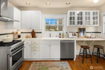 The kitchen balances timeless charm with thoughtful updates, featuring a five-burner Fisher & Paykel gas range, Miele dishwasher, and bar seating.