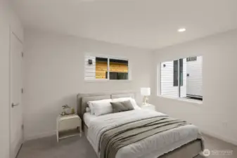 This image is virtually staged. A third generously sized bedroom with dual windows and soft, neutral tones.
