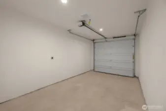 Attached is a garage with clean lines and room for storage, tools, or gym gear.