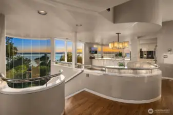 The interior curves soften the straight lines of the home; this also heightened by the choice of natural materials, finishes and colors: oak floors, metal railings, cream and dove tones... a soothing design which doesn't distract from the outdoor spectacular scenery.