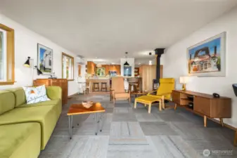 View looking into open living room, dining and work spaces and kitchen