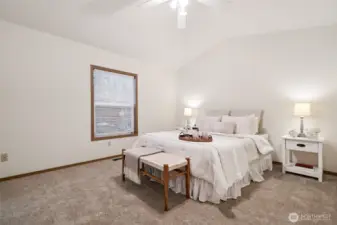 Primary bedroom with vaulted ceiling.