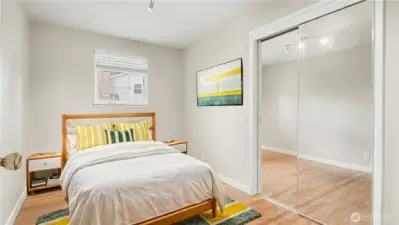 First guest bedroom offering neutral paint color and mirror closet doors. *Virtually staged*