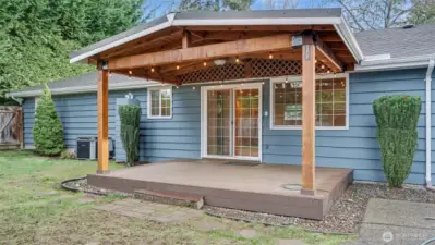 Cozy covered back porch features outdoor ceiling fan for year around enjoyment.