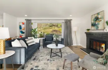 Large bay window and wood burning fireplace add charm and warmth to the living room.