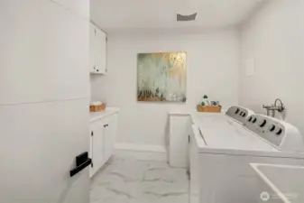 Large, dedicated laundry room with handy utility sink and extra storage.