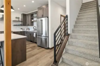 Stairs leading to the upper level which features 2 bedrooms, a shared bath, and a large linen closet.