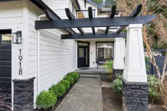 A beautifully designed front entry showcases a modern pergola & sleek black-and-white accents that perfectly blend charm with sophistication offering timeless elegance. Unlock convenience & security with keyless entry and a Ring doorbell, ensuring your home is always accessible & protected with just a touch.