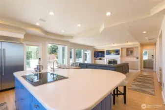 The island is open to another living area with fireplace, perfect for entertaining