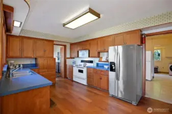 New dishwasher, refrigerator, and microwave (not yet installed, still in box). The doorway on the right leads to a massive utility, laundry, and pantry room. Secondary refrigerator conveys with the property, as do all other appliances.