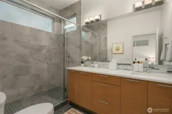 Primary suite bath with large shower and double sinks.