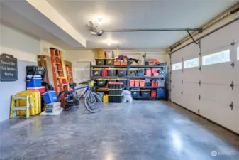 The large 2-car garage includes space for storage/work area. Door at back leads to covered carport area.