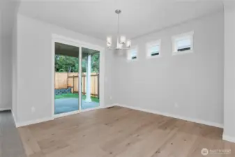 Engineered hardwood extends through the dining room while the oversize sliding door provides an abundance of light and access to the exterior covered patio.