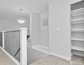 View from 2nd floor landing of stairwell with open rails and decorative art ledges, plus a handy closet.