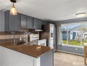 Updated kitchen with tile backsplash, newer stainless steele appliances and updated cabinets.