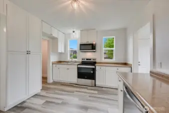 Open kitchen with entrance to the walk in pantry and large cabinets for extra storage