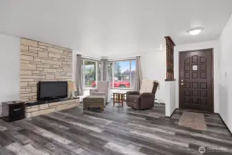 ADU has updated vinyl plank flooring and a fireplace in the living room/dining area