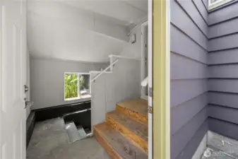 The stairs off of the laundry area head down to the basement.
