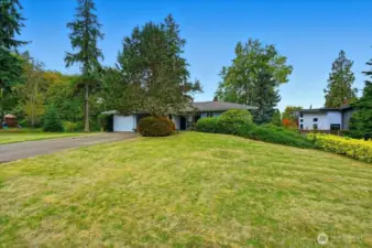 Expansive lawn surrounds existing home.