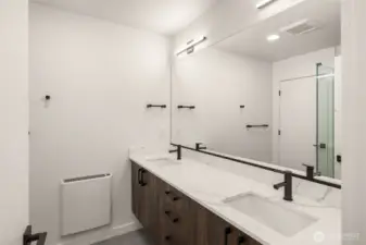 Across from the closet - a dual vanity bath hosting luxury finishes