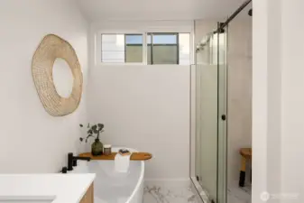En-suite bathroom provides the primary resident with a large luxury shower with rainfall shower head, full tile surround & sliding glass. Just a step outside a deep stand-alone soaking tub for enjoying relaxing evenings.