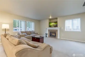 Family room features a cozy gas fireplace and large windows overlooking the back and side yards