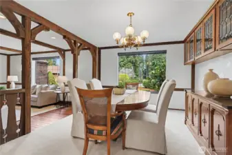 Light-filled dining room with large windows, wood trim, and built-in cabinetry overlooking the landscaped backyard.