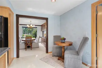 Charming breakfast nook with natural light, patterned wall detail, and convenient access to the kitchen and formal dining room.
