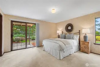 Serene bedroom with sliding glass door opening to the garden, offering abundant natural light and outdoor connection.
