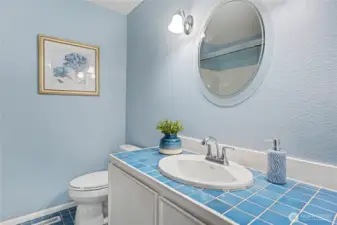 Bright bathroom with blue tile accents, updated fixtures, and a cohesive color palette.
