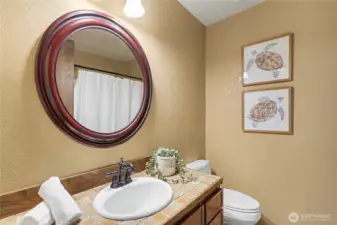 Main bathroom with tile countertop, warm finishes, and a clean, well-maintained layout.
