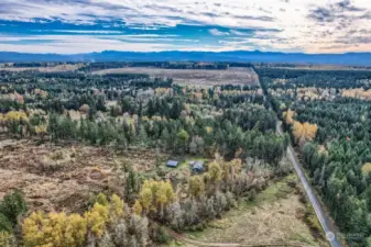 Looking from North to South.  The driveway exits to the left from 8th Ave S and winds thru a greenbelt then opens up to reveal the house, barn and lot.