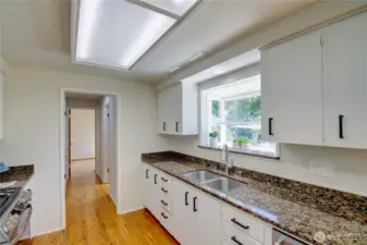 Kitchen with loads of counter space, cabinets, double sink and garden window.