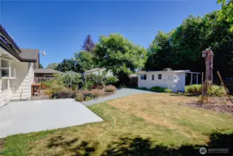 Beautiful private backyard with large garden area, fruit trees, blueberries, outdoor sink, patio with an awning above.